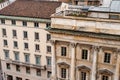 Facade of an old building with a colonnade and balusters on the balconies. Milan, Italy