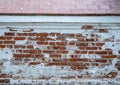 The facade of an old building. Texture of a red brick wall. Background painted with cracked white paint Royalty Free Stock Photo