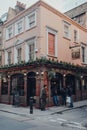 Facade of The Old Coffee House pub in Soho, London UK, people standing outside and walking past, motion blur Royalty Free Stock Photo