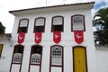 Facade of an old colonial townhouse adorned with divine flags Royalty Free Stock Photo