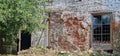 The facade of an old dilapidated house is cracked brickwork. Royalty Free Stock Photo