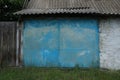 Facade of an old garage with blue metal gates outside