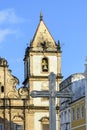 Facade of an old historic church with a large crucifix in the central square in Pelourinho