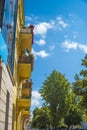 Facade of the old historical building with balconies and flowers against blue sky Royalty Free Stock Photo