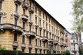 Facade of an old house with carved stone balconies and stucco moldings. Milan, Italy