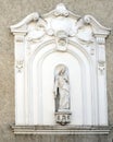 The facade of an old house with niche and sculpture of the Virgi