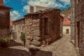 Facade of old house with stone wall between two cobblestone alleys Royalty Free Stock Photo