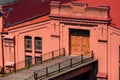 the facade of an old industrial building or warehouse, brick walls painted red, red roof, wooden door for the entrance to the Royalty Free Stock Photo