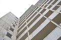 Facade of an old large high-rise apartment building from concrete with balconies against a gray sky, concept for housing and real