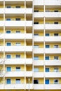 Facade of an old large high-rise apartment building with yellow walls and white balconies, concept for housing and real estate