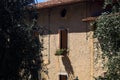 Facade of an old mansion framed by olive trees