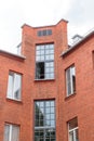 The facade of the old red brick building that was built 100 years ago against the backdrop of the White Sky. Ancient Royalty Free Stock Photo