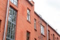 The facade of the old red brick building that was built 100 years ago against the backdrop of the White Sky. Ancient Royalty Free Stock Photo