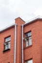 The facade of the old red brick building that was built 100 years ago against the backdrop of the White Sky. Ancient Royalty Free Stock Photo