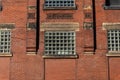 Facade of an old red brick commercial industrial building, decorative brick details and window spaces filled with glass block Royalty Free Stock Photo