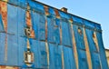 The facade of an old ruinous building is mantled with some blue curtains to protect the pedestrians