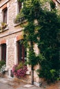 Facade of old stone buildings in Perouges, red windows, flowers, France Royalty Free Stock Photo