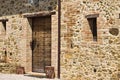 A facade of an old stone farmhouse with a wooden door and two little windows in the italian countryside Tuscany, Italy Royalty Free Stock Photo