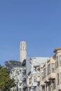 Facade of old victorian houses and coit tower in background in San Francisco