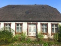 Facade of an old village house in Poland with overgrown front yard garden. Royalty Free Stock Photo