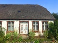 Facade of an old village house in Poland with overgrown front yard garden. Royalty Free Stock Photo