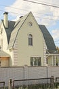 the facade of one gray large private house with white windows under a green tiled roof Royalty Free Stock Photo