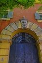 Facade of the orange buildings with doors, windows and shutters and monster face decor in Modena, Italy. Architecture decor and de