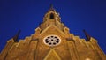 Facade of the organ hall of the Philharmonic in the Polish Church of Irkutsk at night. Bottom view of the Church spire