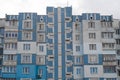 Facade of a panel apartment building of a Soviet house lined with blue tiles