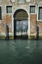 Facade of partially mossy old brick house with wooden vintage door Royalty Free Stock Photo