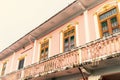 Facade of pink building with balcony and wooden windows in old town of Phuket, Thailand. Ornaments Royalty Free Stock Photo