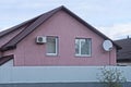 facade of a pink private house with white windows under a brown tiled roof Royalty Free Stock Photo