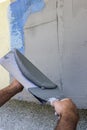 Facade plaster hand smoothing out wall with trowel 2