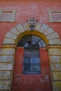 Facade of the red building with doors, windows and shutters and monster face decor in Modena, Italy. Architecture decor and design