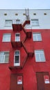 The facade of a red house with an iron fire escape.