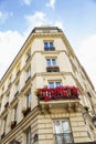 The facade of a residential building in the center of Paris against a bright blue sky. Beautifully decorated flower balconies Royalty Free Stock Photo