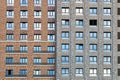 The facade of a residential high-rise building in brown and gray tones. Rows of windows. Urban residential skyscraper