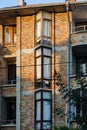 The facade of a residential unfinished building of faded red brick. Three-storey home typical of Europe at sunset. House with Royalty Free Stock Photo