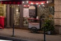 Facade of retro cafe with red Christmas decorations and small Christmas tree in front of entrance and windows. Travel Europe. Royalty Free Stock Photo