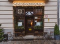 Facade of retro restaurant with Christmas decorations in front of entrance and empty tables and wooden chairs. Royalty Free Stock Photo