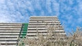 Facade with rows of white, concrete balconys and green structure of building. Royalty Free Stock Photo