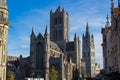 Facade of Saint Nicholas` Church Sint-Niklaaskerk with the clock tower of Belfry of Ghent Het Belfort at the background, in Royalty Free Stock Photo