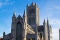 Facade of Saint Nicholas` Church Sint-Niklaaskerk with the clock tower of Belfry of Ghent Het Belfort at the background, in