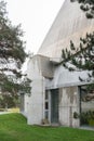 Facade of the Saint-Pierre Catholic church in the garden under light sky, vertical shot