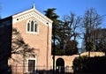Facade of the Scrovegni Chapel and many trees, illuminated by the sun, the left side in the shade in Padua.