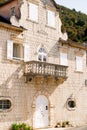 Facade of a stone building with shutters and a balcony. Perast, Montenegro