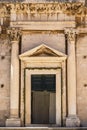 Facade of stone entrance with pillars on Stradun main street in Dubrovnik old town in Croatia summer Royalty Free Stock Photo