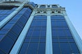 Part of a tall building of concrete and blue glass against the sky Royalty Free Stock Photo