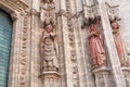 Facade with 16th century sculptures of Roman Catholic Seville Cathedral , Spain. Priest and women reading Bible Royalty Free Stock Photo