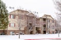 Facade of three story apartment with snow covered yard and roof in winter Royalty Free Stock Photo